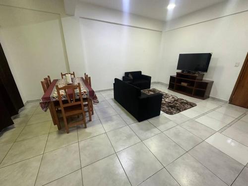 a living room with a table and a tv at Departamento Circuito Comercial in Encarnación