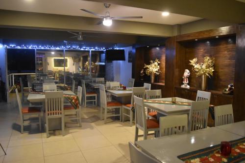 un comedor con mesas, sillas y luces en Hotel Boutique Boca - Veracruz, en Boca del Río