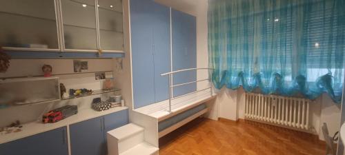 a childs room with blue cabinets and a window at La Casa di Cristina in Livorno