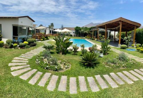 een tuin met een zwembad en een huis bij Kuyayky Lodge in Lima