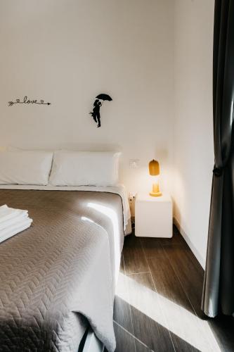 a white bedroom with a bed and a side table at Le Contrade Vico Alba in Monopoli