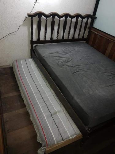 a bed sitting in a corner of a room at Casa Indaia Caraguatatuba in Caraguatatuba