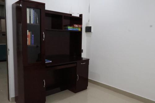 a book shelf and a desk in a room at Mandolin Homestay in Dibrugarh - 2BHK Apartment in Dibrugarh