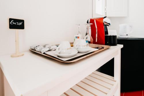 a white counter with a tray with dishes on it at Le Contrade Vico Alba in Monopoli