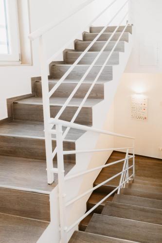 a staircase with white railings and wood floors at Le Contrade Vico Alba in Monopoli