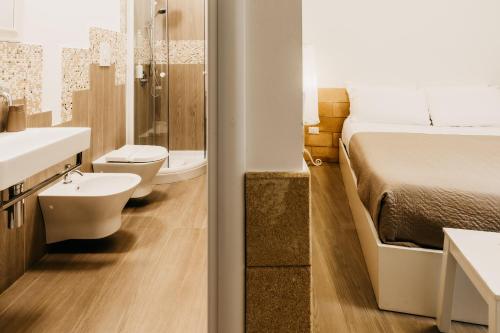 a bathroom with two toilets and a bed and a sink at Le Contrade Vico Alba in Monopoli
