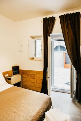 a hotel room with a bed and a window at Le Contrade Vico Alba in Monopoli