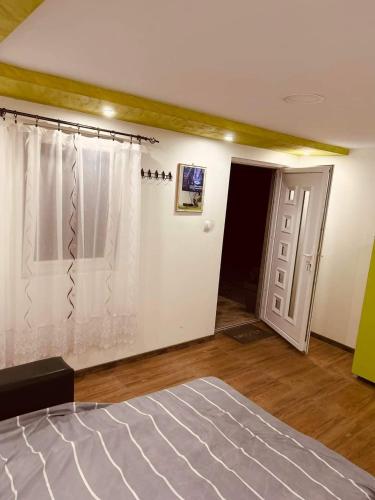 an empty room with a bed and a door at NP Apartman Banja Jokin Grab -Bogatić 