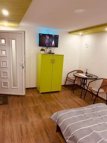 a bedroom with a green cabinet and a table at NP Apartman Banja Jokin Grab -Bogatić 