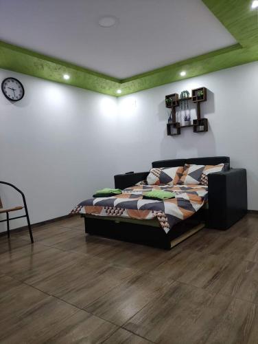 a bedroom with a bed and a clock on the wall at NP Apartman Banja Jokin Grab -Bogatić 