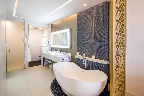 baño con bañera blanca grande y lavamanos en Residential Retreat 2 Bedroom Suite Garza Blanca Los Cabos Resort & Spa en Cabo San Lucas