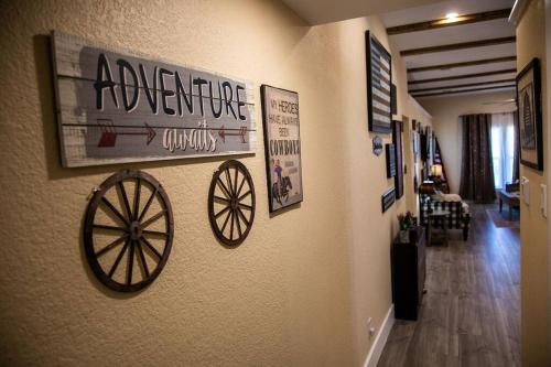 a hallway with a wall with a wagon wheel on it at Stockyards Cowtown Outpost-Less than 4 minutes to StockYards-Sleeps 8 in Fort Worth