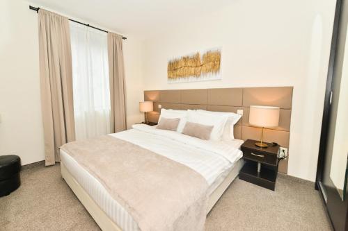 Un dormitorio con una gran cama blanca y una ventana en Best Western Art Plaza Hotel, en Sofía