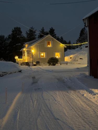 a house in the snow at night with lights at Sjarmerende og romslig bolig, omgitt av vakker natur in Molde