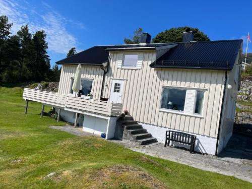 a small house with a porch and a bench at Sjarmerende og romslig bolig, omgitt av vakker natur in Molde