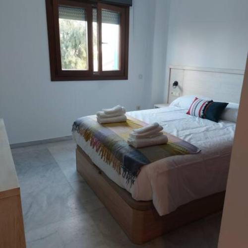 a bedroom with a bed with towels on it at IJD apartments 126 PARKING GRATIS Y PISCINA in Bormujos