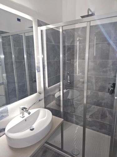 uma casa de banho com um lavatório branco e um chuveiro em Hotel Trasimeno Bittarelli em Castiglione del Lago