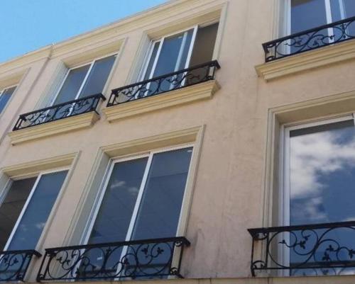 a building with windows and balconies on the side of it at APARTAMENTOS FRERS in Martínez