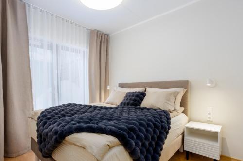 una camera da letto con un letto con una coperta blu sopra di Tartu City Center Apartments a Tartu