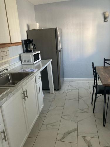 a kitchen with a refrigerator and a table with a microwave at Edgewater Inn in Myrtle Beach