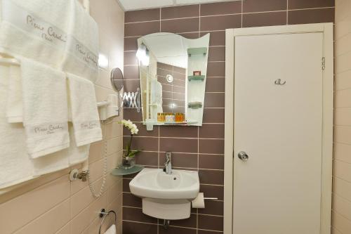 a bathroom with a sink and a toilet and a mirror at Art Plaza Hotel in Sofia