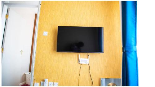 telewizor z płaskim ekranem wiszący na ścianie w obiekcie Anne's Luxurious Thindigua Apartment w mieście Nairobi