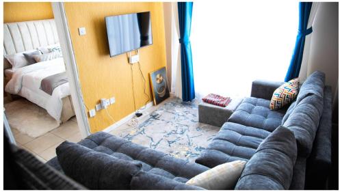 - un salon avec un canapé et une télévision dans l'établissement Anne's Luxurious Thindigua Apartment, à Nairobi