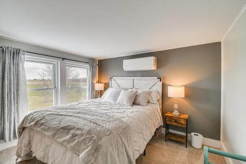 ein Schlafzimmer mit einem großen Bett und einem Fenster in der Unterkunft Auburn Finger Lakes Farmhouse with Open Views! in Auburn