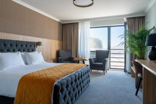 ein Hotelzimmer mit einem Bett und einem großen Fenster in der Unterkunft Mazurkowa - z widokiem na Karkonosze i Śnieżkę, darmowy parking, obok restauracja Mazurkowa Chata in Jelenia Góra