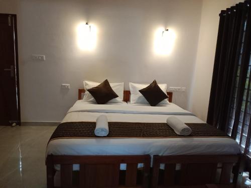 a bedroom with a large bed with two pillows at Casa Branca Retreat in Varkala