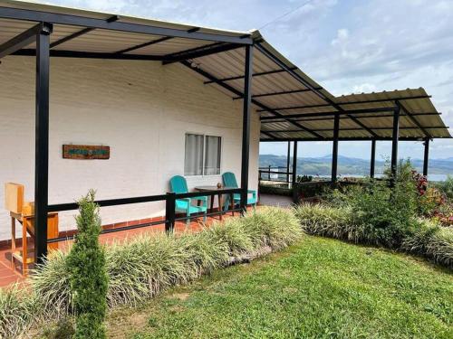a patio with chairs and a table on a house at Finca Aguadalupe, Lago Calima in Calima