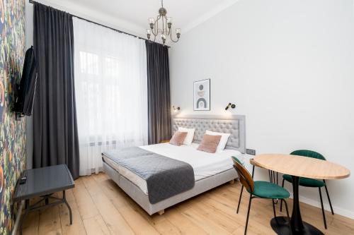 a bedroom with a bed and a table and chairs at Wawel Apartments - Old Town in Kraków