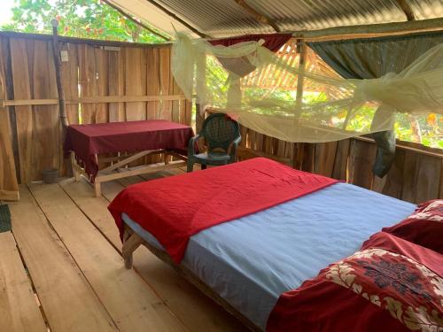 1 dormitorio con 1 cama y un escritorio en una tienda de campaña en Miguel Surf Camp en Quepos