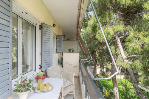 un portico con tavolo e sedie sul balcone di Charming Apartment in Varkiza a Varkiza