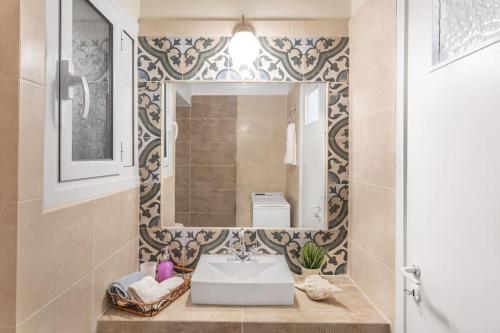 bagno con lavandino e specchio di Charming Apartment in Varkiza a Varkiza