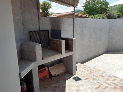 eine Betonwand mit einem Regal auf einer Terrasse in der Unterkunft Departamento Noemí in La Cumbre