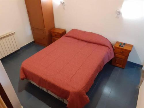 ein Schlafzimmer mit einem Bett mit einer roten Decke in der Unterkunft Departamento Noemí in La Cumbre