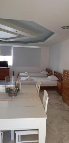 ein weißes Zimmer mit einem Tisch und einem Bett in der Unterkunft Algo2 in Salamís