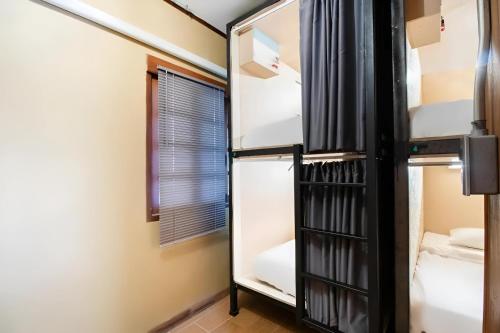 Zimmer mit 2 Etagenbetten und einem Fenster in der Unterkunft Cozy Hub Hostel in Chiang Mai