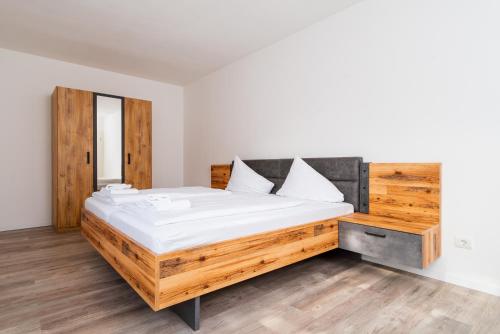 a bedroom with a large wooden bed with white sheets at Gabriel´s Apartment´s in Dortmund