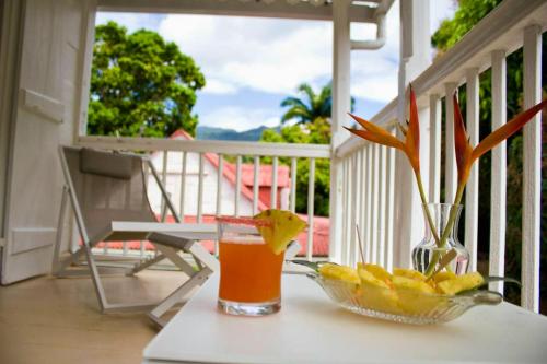 a glass of juice and a bowl of fruit on a porch at Villa de 6 chambres avec wifi a Vieux Habitants a 3 km de la plage in Vieux-Habitants