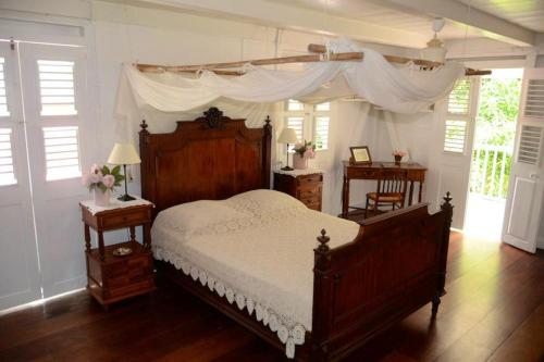 een slaapkamer met een groot bed met een baldakijn bij Villa de 6 chambres avec wifi a Vieux Habitants a 3 km de la plage in Vieux-Habitants