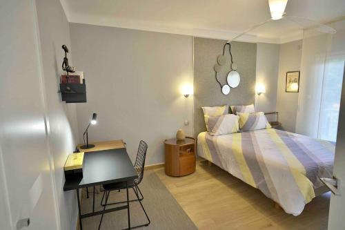 une chambre avec un lit, un bureau et une table dans l'établissement Appartement chic à Cannes, avec terrasse et cheminée, 83 m², à Cannes