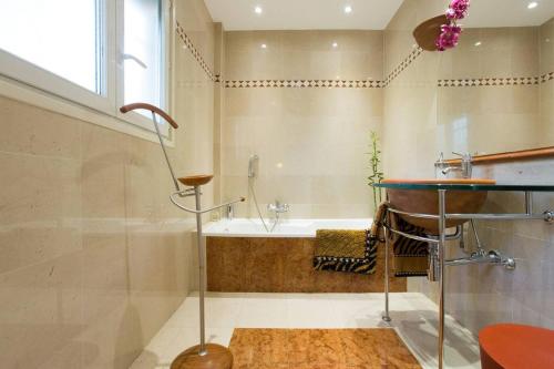 une salle de bain avec une baignoire et un lavabo dans l'établissement Appartement chic à Cannes, avec terrasse et cheminée, 83 m², à Cannes