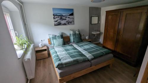 um quarto com uma cama com um cobertor verde e branco em Ferienwohnung Angie em Niederrotweil