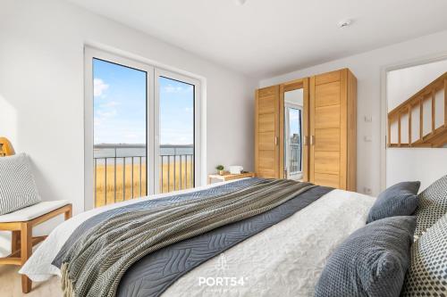 Schlafzimmer mit einem Bett und Meerblick in der Unterkunft Blaue Brise in Olpenitz