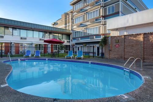 a large swimming pool in front of a building at Days Inn by Wyndham Victoria Airport Sidney in Sidney