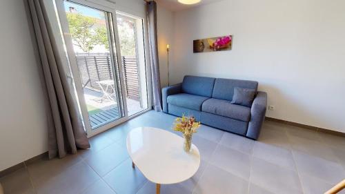 a living room with a couch and a table and a window at Résidence Villa Branda in Calvi