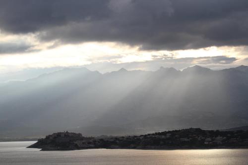 a view of the water with mountains in the background at Résidence Villa Branda in Calvi