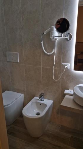 a bathroom with a toilet and a bidet and a sink at Hotel Trasimeno Bittarelli in Castiglione del Lago